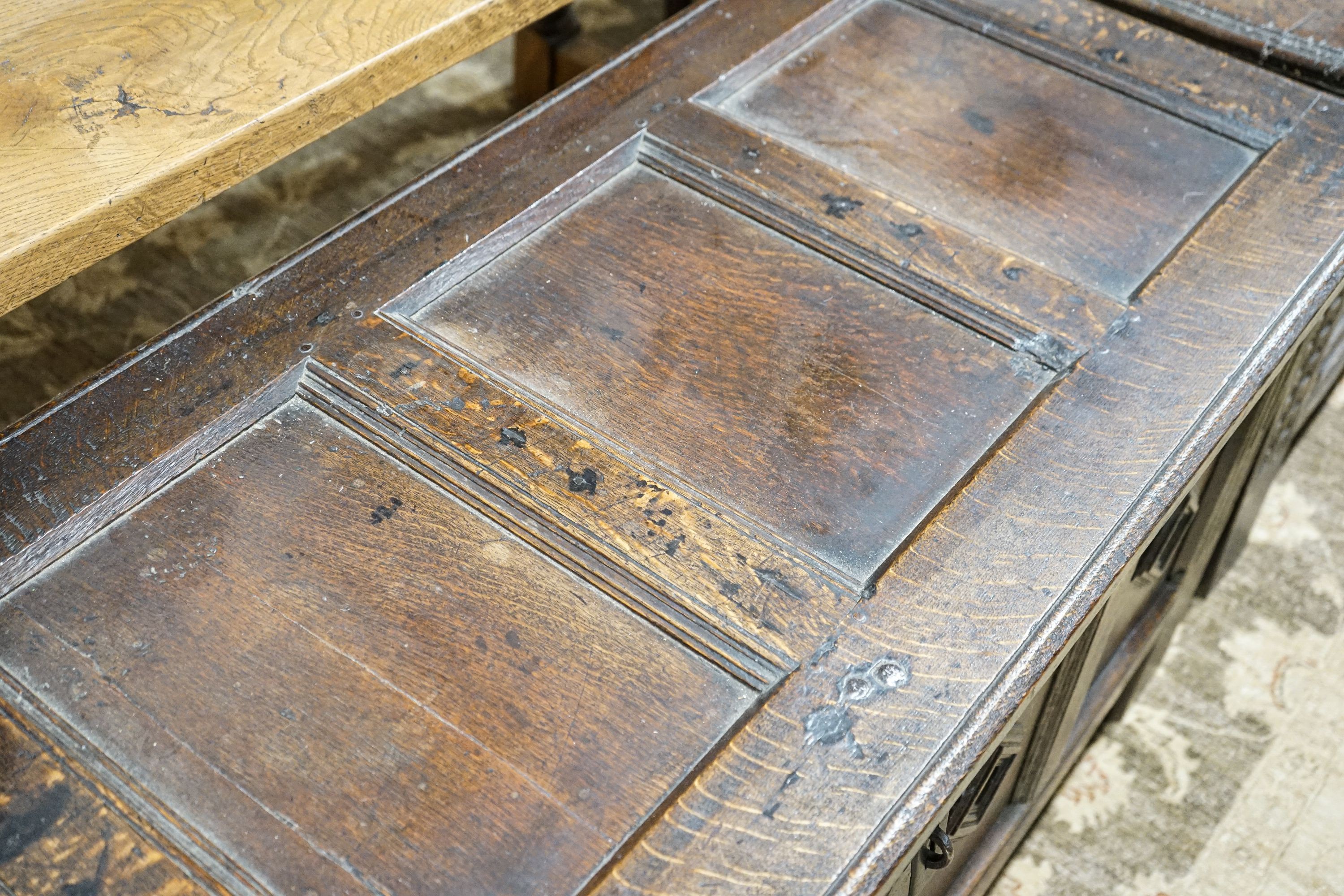 A late 17th century oak coffer, with four panel top and carved front, length 151cm, depth 58cm, height 69cm